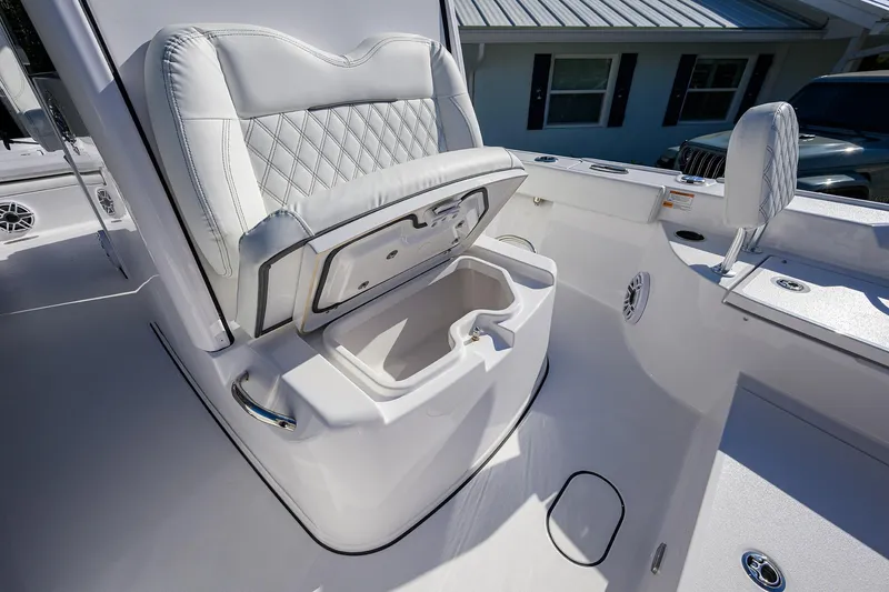 Slide: The Image of 2023 Sportsman Masters 267 Bay Boat interior with cushioned seating and storage compartment. - 16