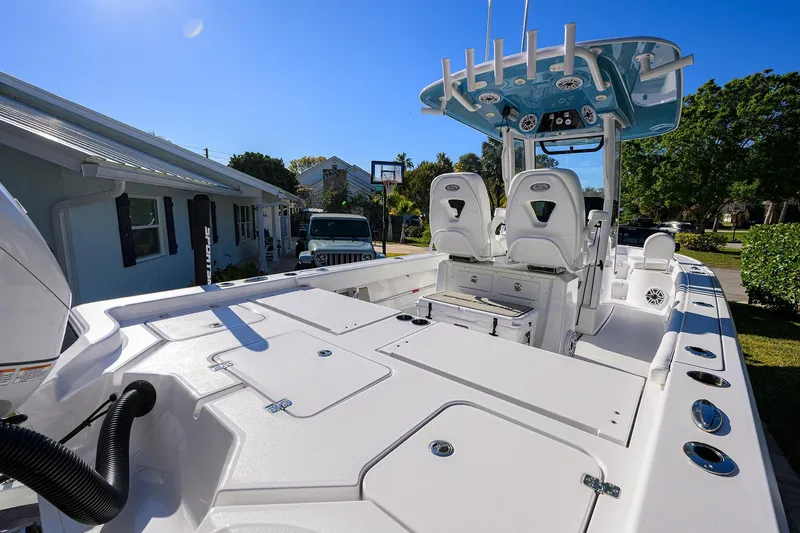 Slide: The Image of 2023 Sportsman Masters 267 Bay Boat with sleek design and spacious deck in a residential setting. - 18