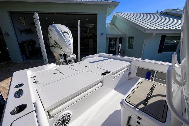 Slide: The Image of 2023 Sportsman Masters 267 Bay Boat with Yamaha engine, docked near a modern house. - 22