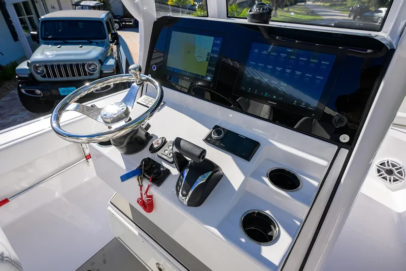 Slide: The Image of 2023 Sportsman Masters 267 Bay Boat dashboard with steering wheel and digital displays. - 37