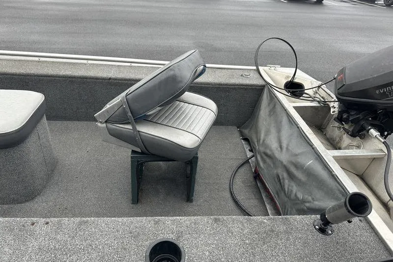 Slide: The Image of 1992 Tracker Panfish 16 boat interior with seating and motor, featuring gray upholstery. - 6