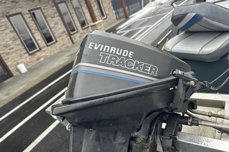 Slide: The Image of 1992 Tracker Panfish 16 boat with Evinrude motor, parked near a stone building. - 7