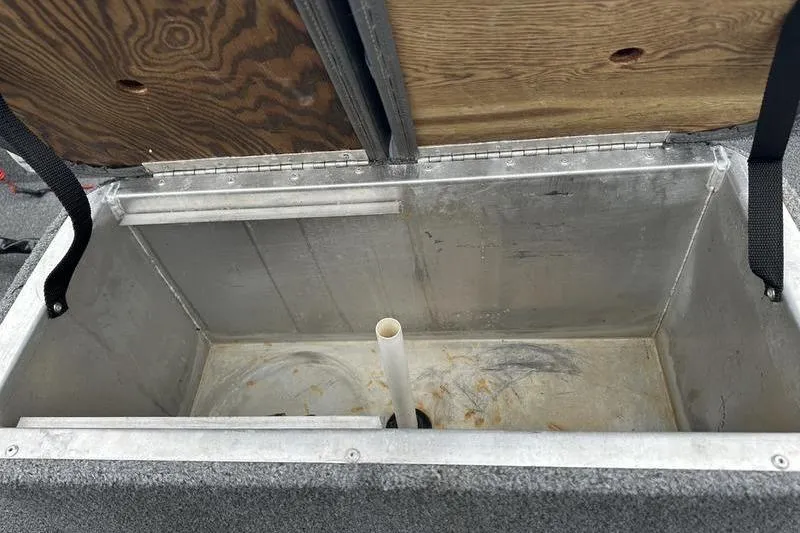 Slide: The Image of Open storage compartment in 1992 Tracker Panfish 16 boat, featuring metal interior and wooden lid. - 8