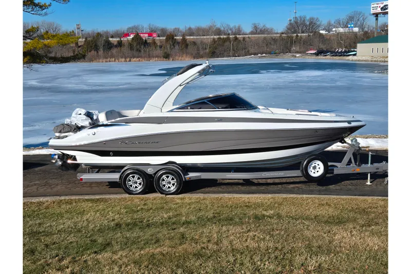 The Image of 2018 Crownline 275 SS boat on trailer by frozen lake, clear sky background. - 0