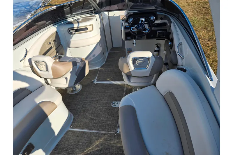 Slide: The Image of 2018 Crownline 275 SS boat interior with beige and gray seating, steering wheel, and dashboard. - 12