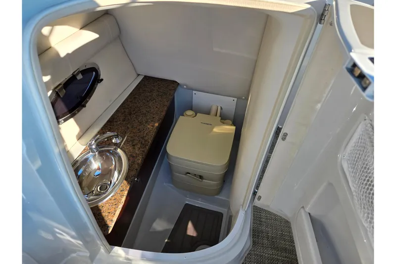 Slide: The Image of 2018 Crownline 275 SS boat interior with sink and portable toilet. - 17
