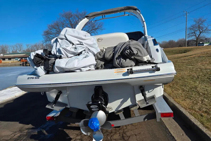Slide: The Image of 2018 Crownline 275 SS boat on trailer, covered, sunny day, outdoor setting. - 2