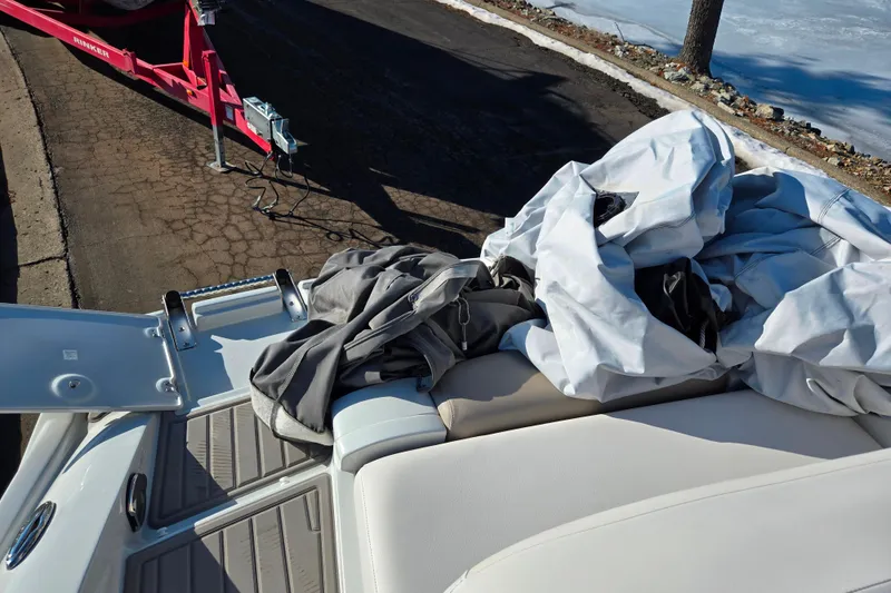 Slide: The Image of 2018 Crownline 275 SS boat with cover, parked on a trailer by a lakeside. - 27