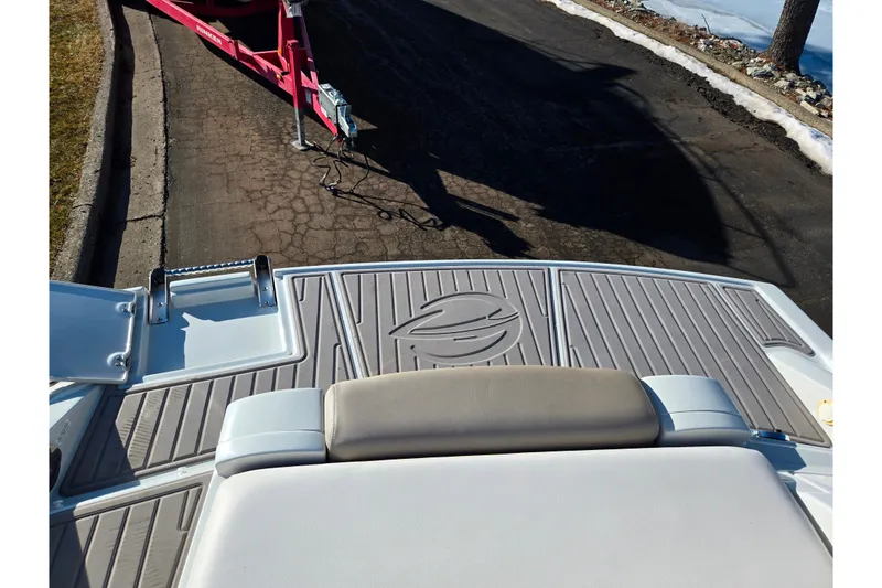 Slide: The Image of 2018 Crownline 275 SS boat with swim platform and ladder, parked on a paved road. - 29