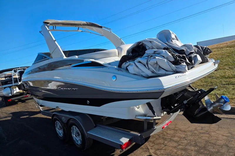 Slide: The Image of 2018 Crownline 275 SS boat on trailer, covered, under clear blue sky. - 3