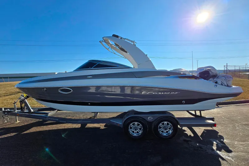 Slide: The Image of 2018 Crownline 275 SS boat on trailer under bright sun. - 4