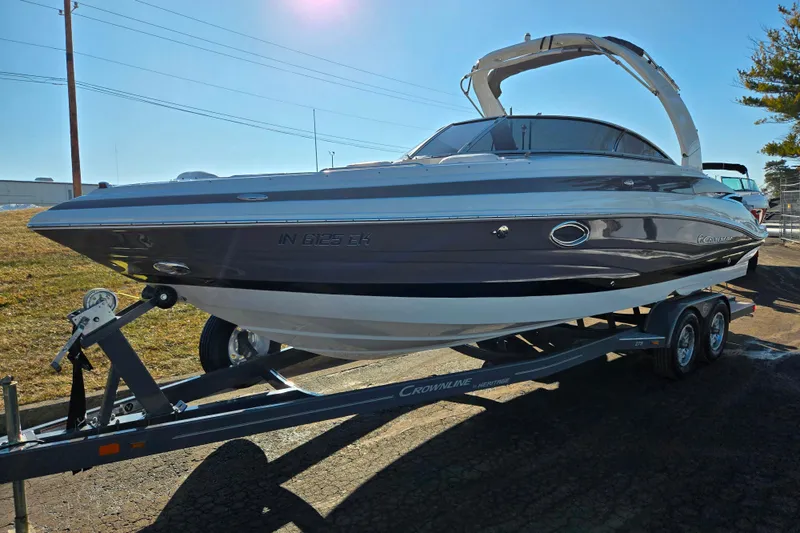 Slide: The Image of 2018 Crownline 275 SS boat on trailer, parked outdoors under clear sky. - 5