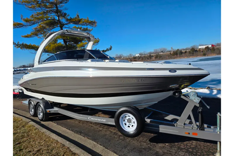 Slide: The Image of 2018 Crownline 275 SS boat on trailer by a lake, clear blue sky. - 8