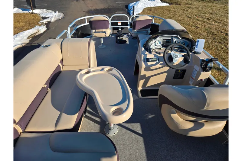 Slide: The Image of 2018 Sun Tracker Bass Buggy 18 DLX pontoon boat interior with beige seating and steering console. - 24