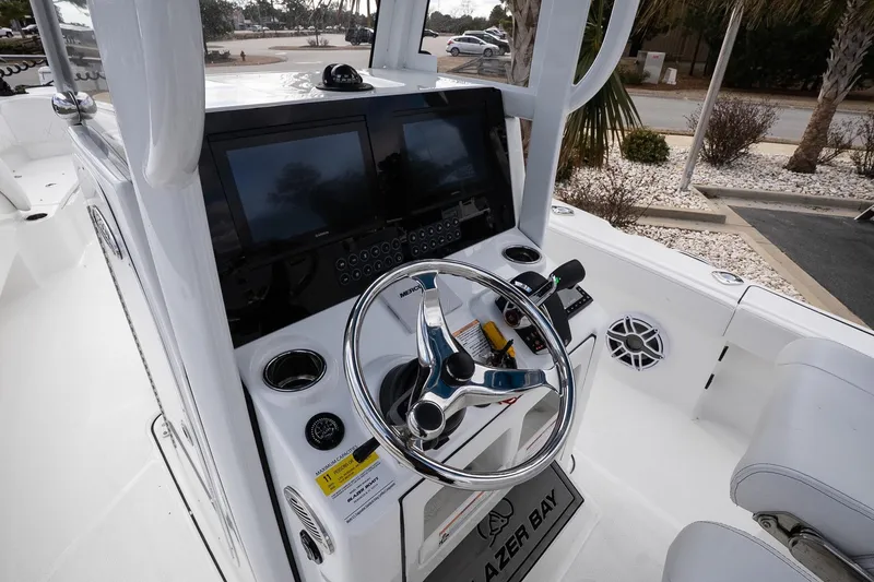 Slide: The Image of 2026 Blazer Bay Makaira 2800 boat cockpit with steering wheel and dual screens. - 22