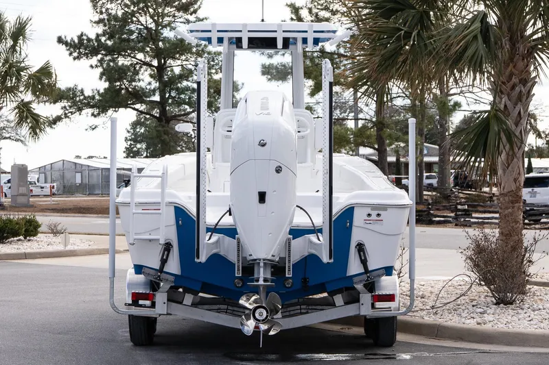 Slide: The Image of 2026 Blazer Bay Makaira 2800 boat on trailer, rear view, parked near palm trees. - 6