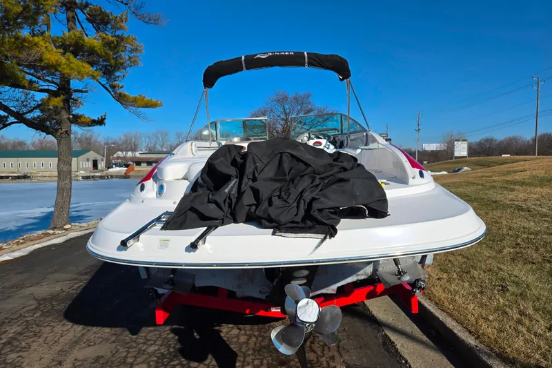 Slide: The Image of 2007 Rinker 262 Captiva Cuddy boat on trailer, parked near a lake. - 2