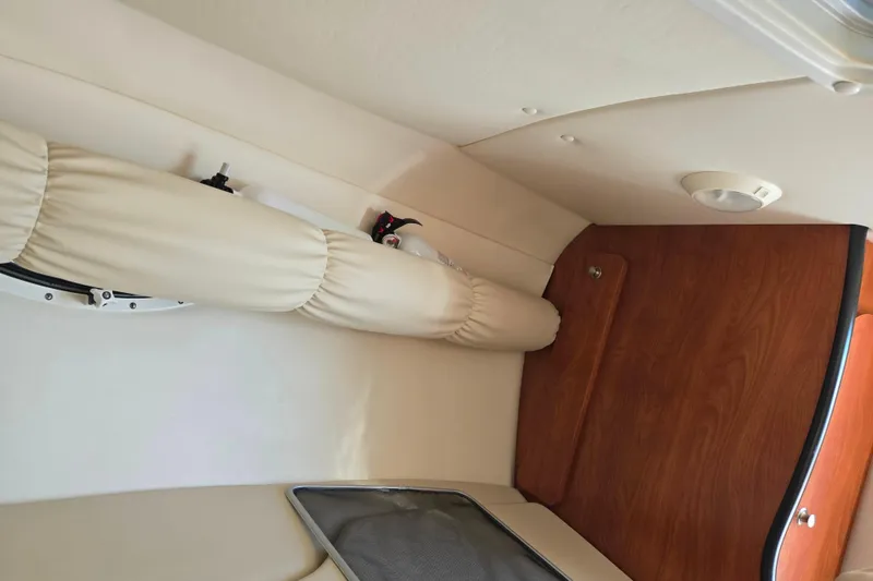 Slide: The Image of 2007 Rinker 262 Captiva Cuddy cabin interior with wood paneling and cushioned seating. - 22