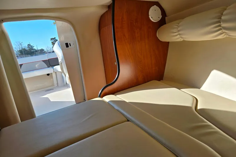 Slide: The Image of 2007 Rinker 262 Captiva Cuddy cabin interior with beige seating and wood paneling. - 23