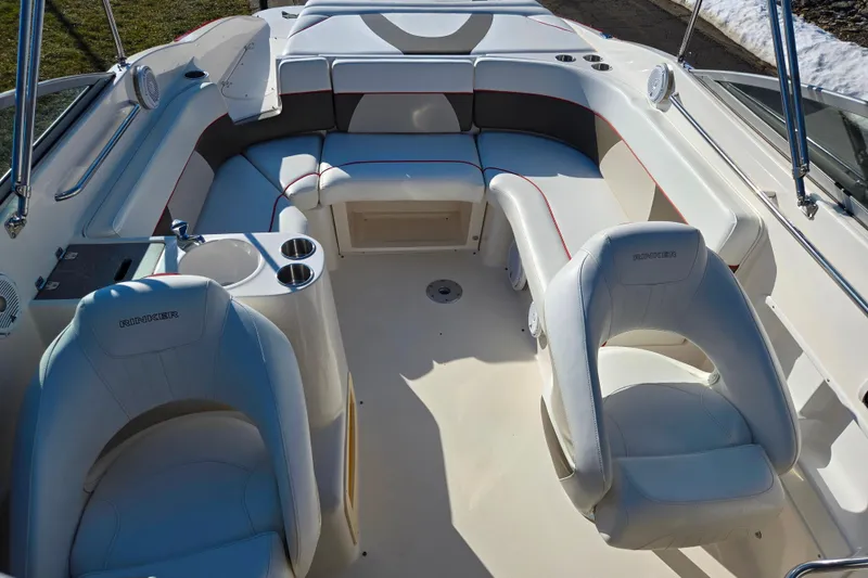 Slide: The Image of 2007 Rinker 262 Captiva Cuddy boat interior with white seating and cup holders. - 24