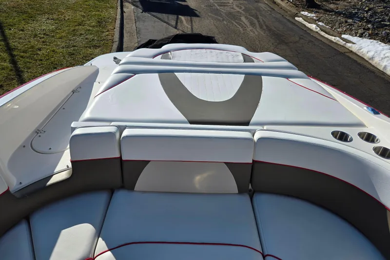 Slide: The Image of 2007 Rinker 262 Captiva Cuddy boat interior with cushioned seating and cup holders. - 25