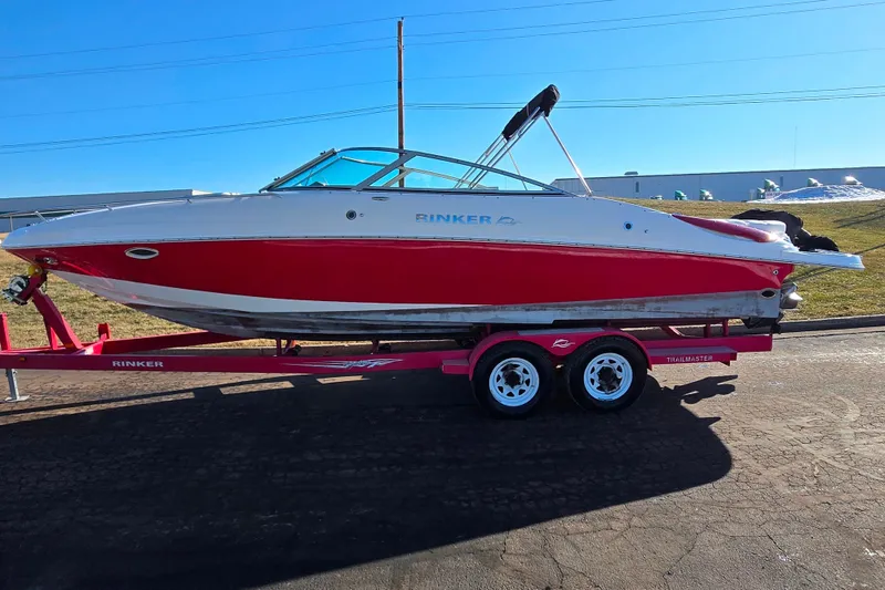 Slide: The Image of 2007 Rinker 262 Captiva Cuddy boat on trailer, red and white design, sunny day. - 4