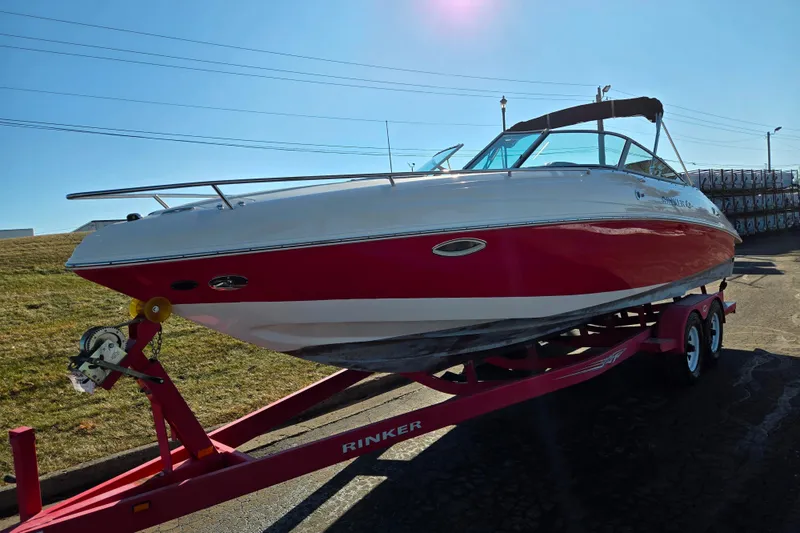 Slide: The Image of 2007 Rinker 262 Captiva Cuddy boat on trailer, red and white design, sunny day. - 5