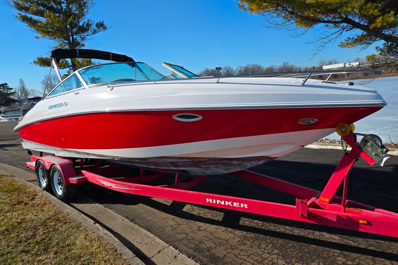 Slide: The Image of 2007 Rinker 262 Captiva Cuddy boat on red trailer, parked outdoors. - 8