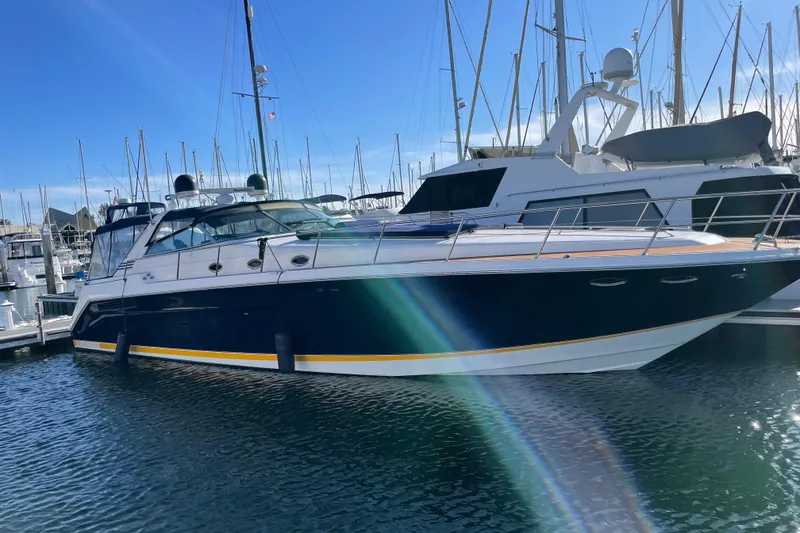The Image of 1999 Sea Ray 500 Sundancer yacht docked at marina under clear blue sky. - 0