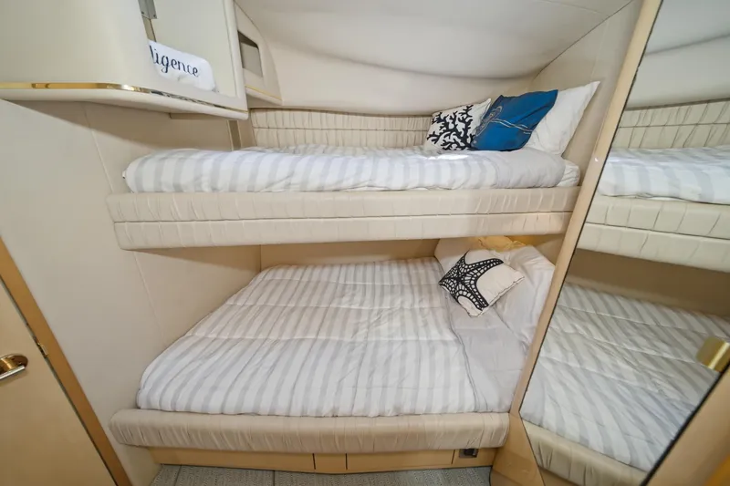 Slide: The Image of 1999 Sea Ray 500 Sundancer cabin with bunk beds and decorative pillows. - 26