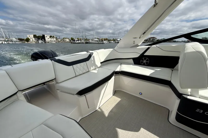 Slide: The Image of 2021 Regal 23 OBX boat interior with luxurious white seating and waterfront view. - 13