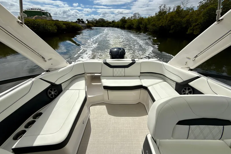 Slide: The Image of 2021 Regal 23 OBX boat interior with luxurious seating on a scenic waterway. - 15