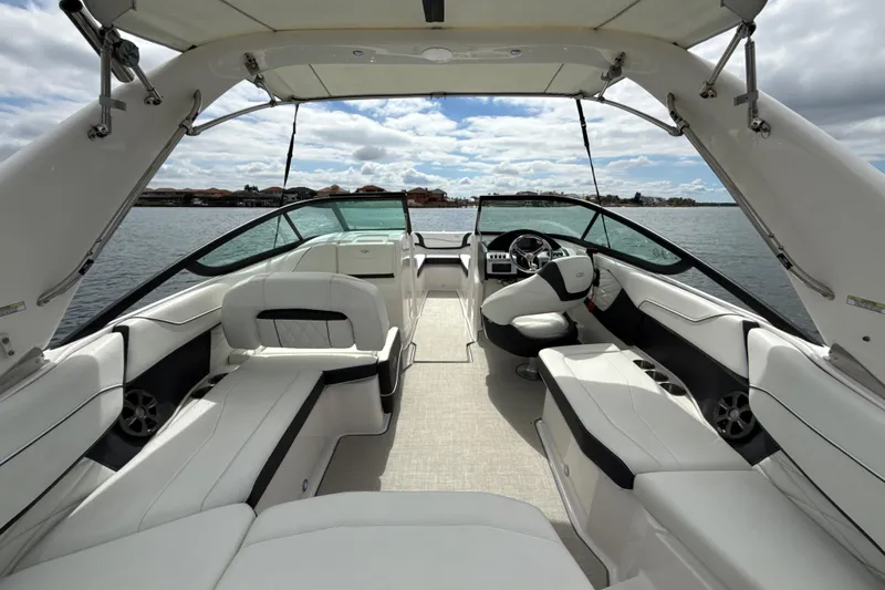 Slide: The Image of 2021 Regal 23 OBX boat interior with luxurious seating and steering, on a calm lake. - 3