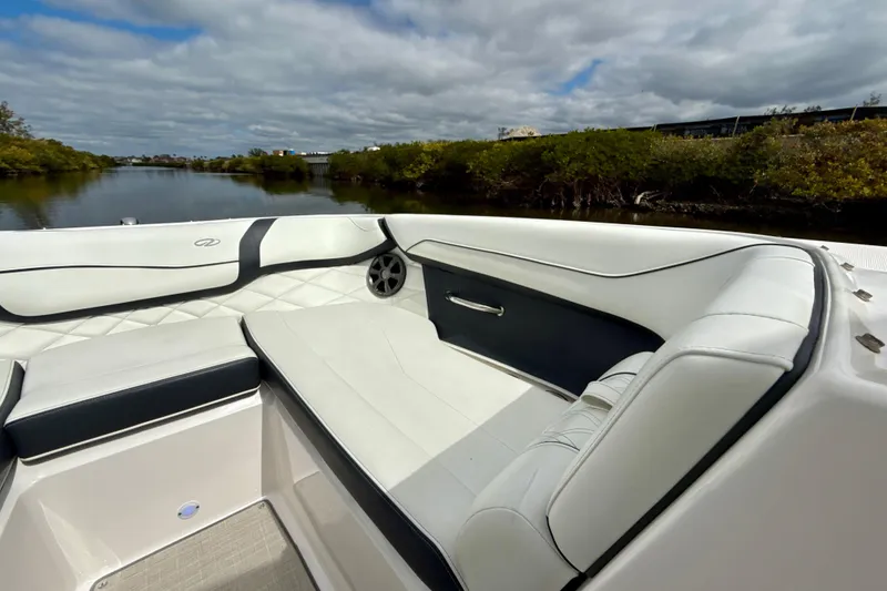 Slide: The Image of 2021 Regal 23 OBX boat interior with white seating, near a calm river. - 8
