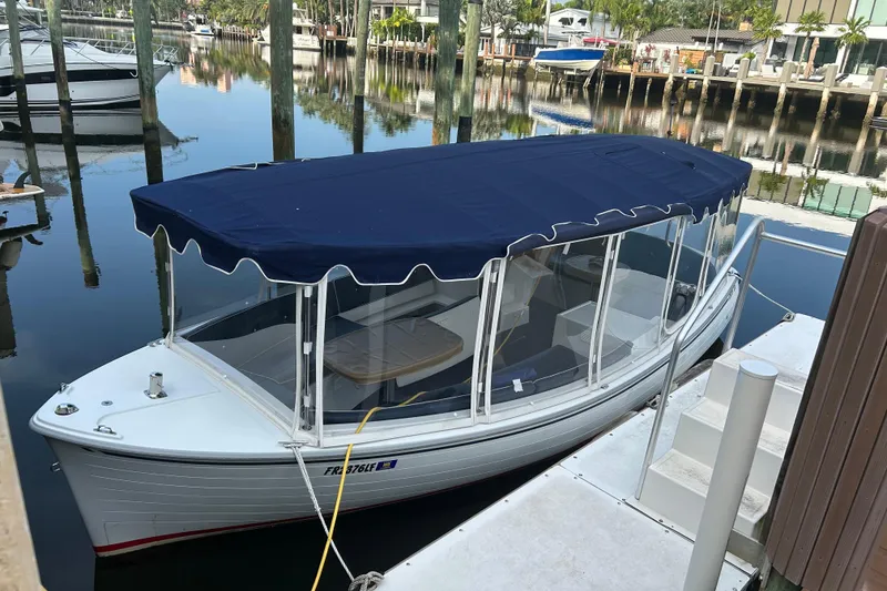 The Image of 2016 Duffy D-22 Bay Island boat docked with blue canopy in a marina. - 1