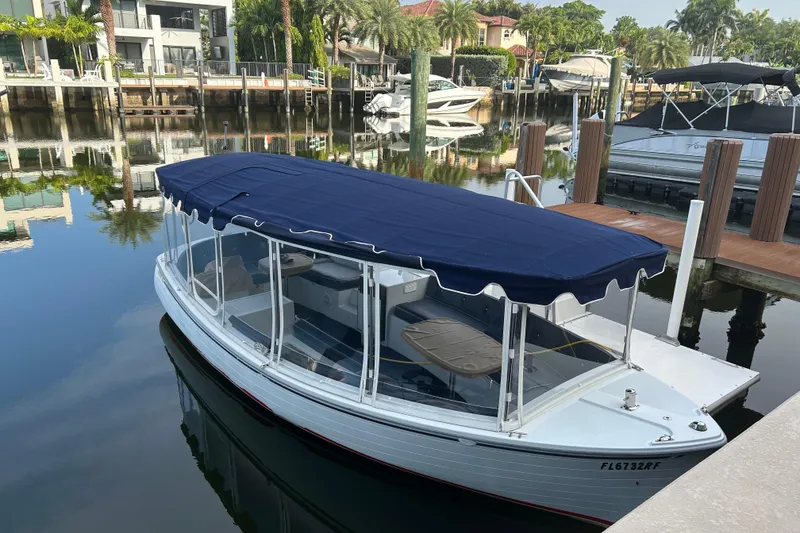 Slide: The Image of 2016 Duffy D-22 Bay Island electric boat docked in a serene marina setting. - 2