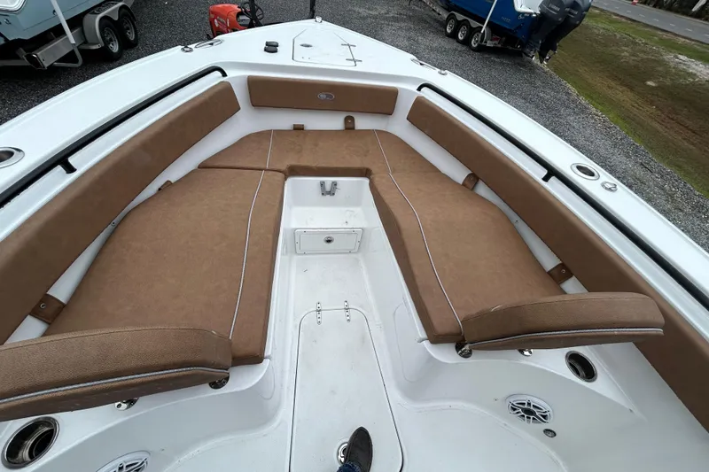 Slide: The Image of 2025 Sea Hunt Ultra 265 SE boat interior with brown cushioned seating. - 10