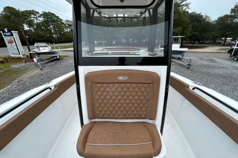 Slide: The Image of 2025 Sea Hunt Ultra 265 SE boat interior with brown cushioned seating. - 11