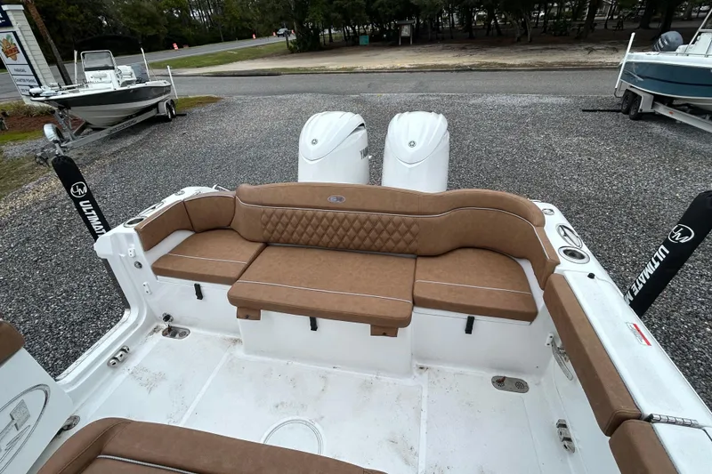 Slide: The Image of 2025 Sea Hunt Ultra 265 SE boat interior with brown cushioned seating and dual engines. - 12