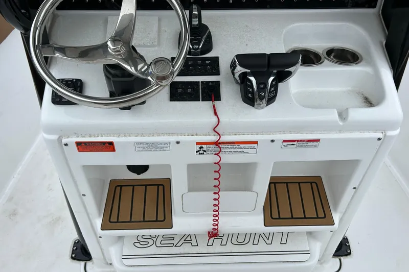 Slide: The Image of Control panel of 2025 Sea Hunt Ultra 265 SE boat with steering wheel and controls. - 15