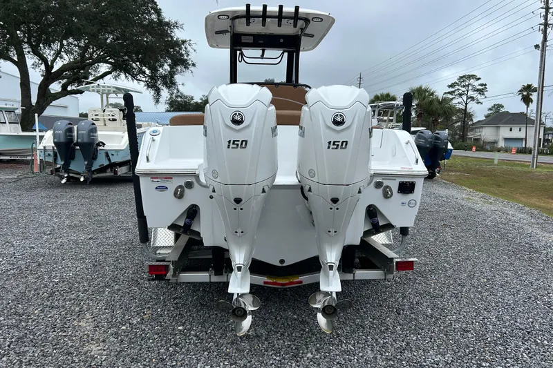 Slide: The Image of 2025 Sea Hunt Ultra 265 SE boat with dual Yamaha 150 engines, parked on gravel. - 4