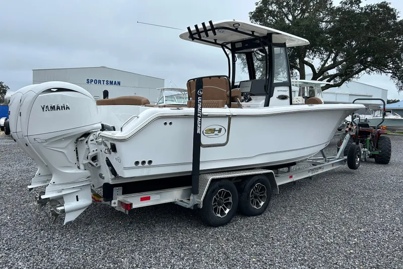 Slide: The Image of 2025 Sea Hunt Ultra 265 SE boat on trailer with Yamaha engines, parked outdoors. - 5