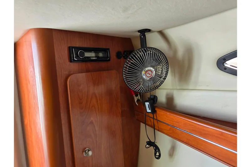 Slide: The Image of 2007 Rinker 246 Captiva Cuddy interior with fan and stereo system. - 18