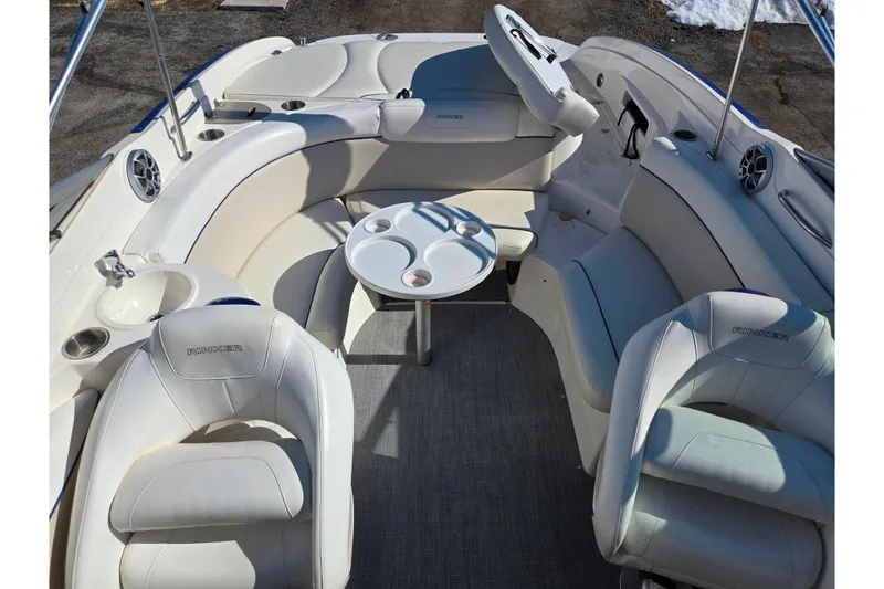 Slide: The Image of 2007 Rinker 246 Captiva Cuddy boat interior with white seating and round table. - 20