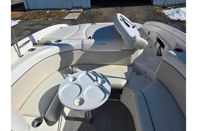 Slide: The Image of 2007 Rinker 246 Captiva Cuddy boat interior with white seating and round table. - 21
