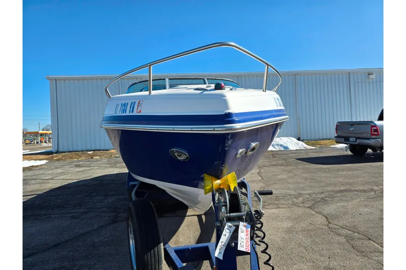 Slide: The Image of 2007 Rinker 246 Captiva Cuddy boat on trailer, parked outdoors under clear blue sky. - 6