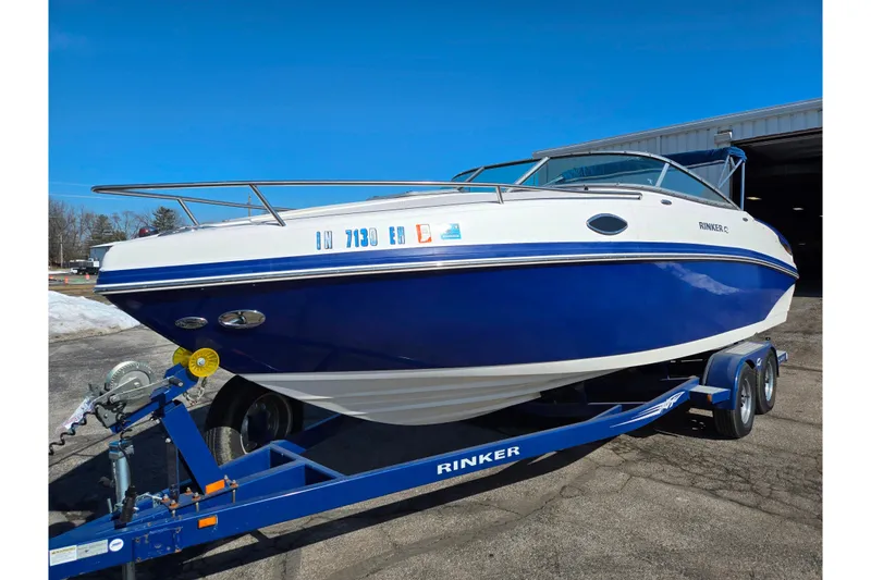 Slide: The Image of 2007 Rinker 246 Captiva Cuddy boat on trailer, blue and white design. - 8