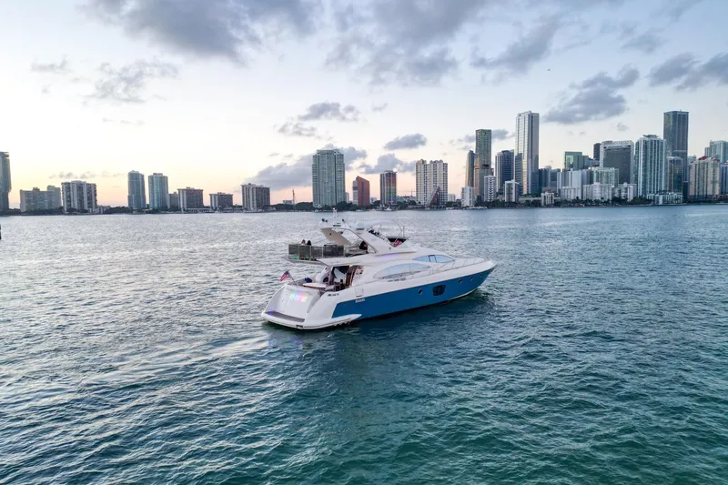 Slide: The Image of 2007 Azimut 68E yacht cruising near city skyline at sunset. - 2