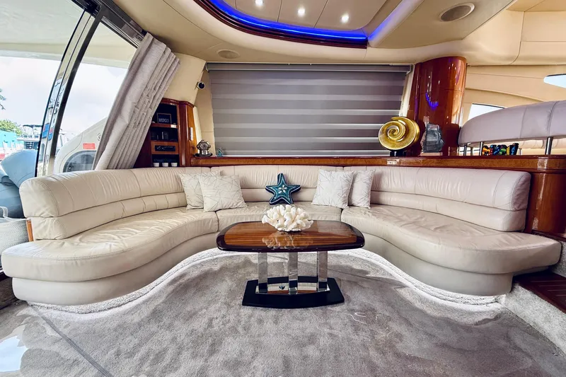 Slide: The Image of Luxurious interior of 2007 Azimut 68E yacht with elegant wood finishes and model sailboat. - 54
