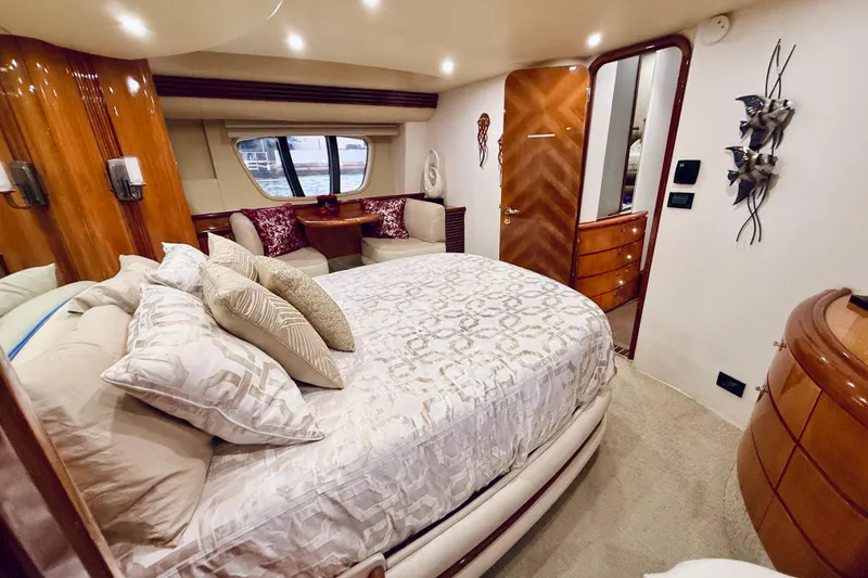 Slide: The Image of 2007 Azimut 68E yacht cruising on calm waters at sunset, with city skyline in background. - 73